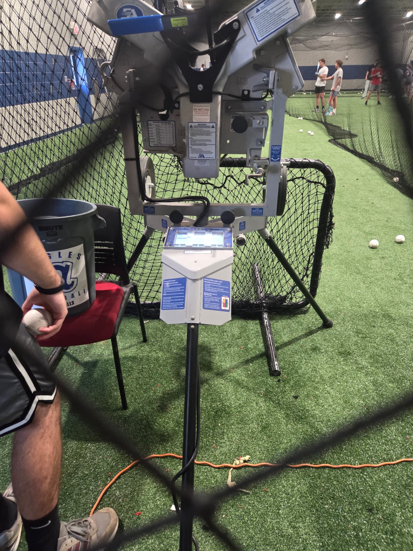 Hack Attack M3 machine with pitch locator inside an indoor batting cage