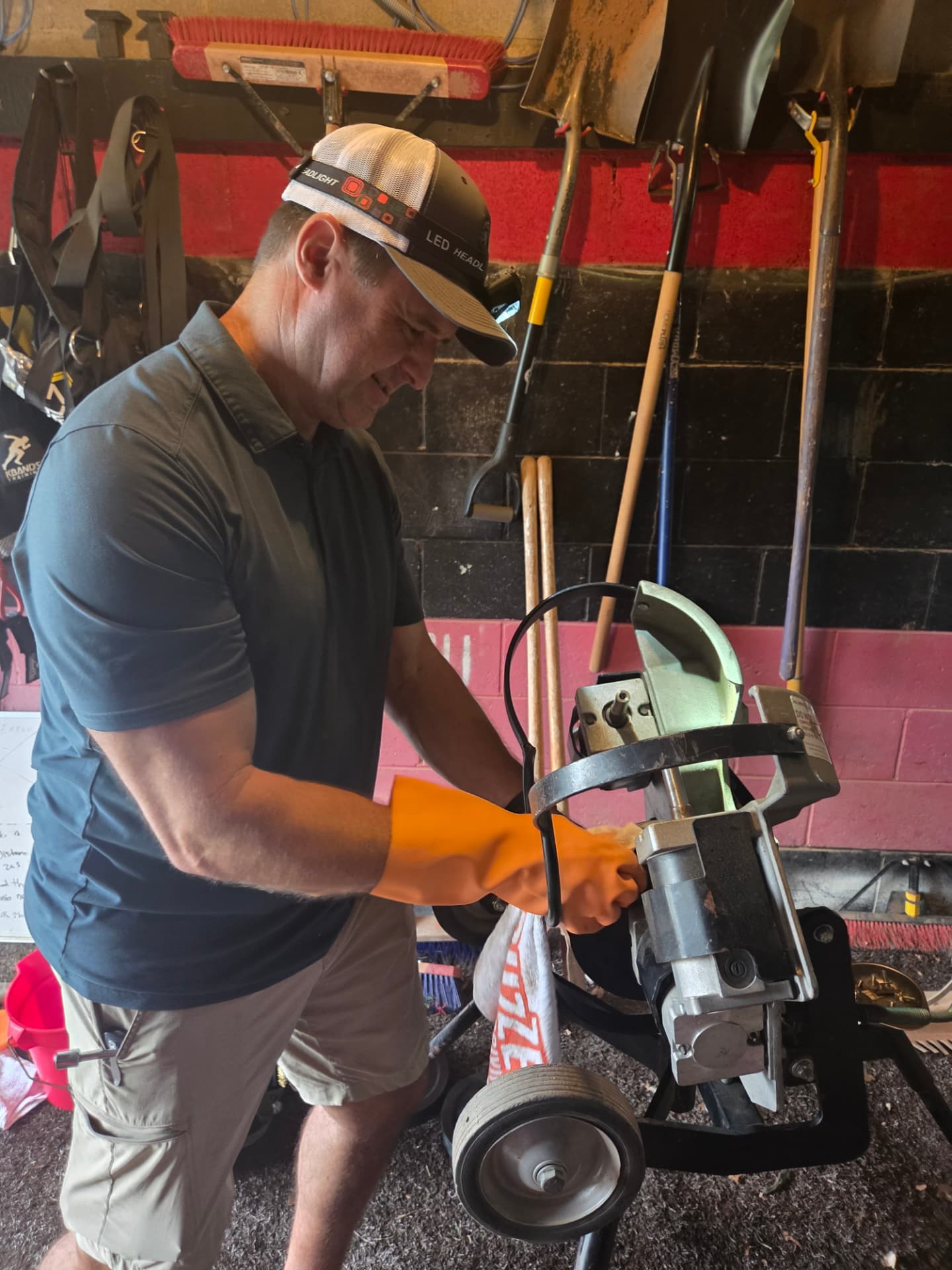 PSA technician servicing a pitching machine in a maintenance shed